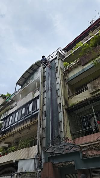 御水師傅以繩索作業施工外牆